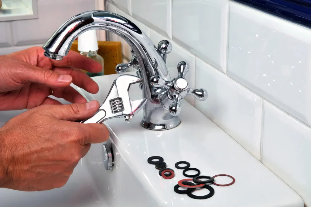 Plumber performing maintenance on a bathroom faucet in Longmont