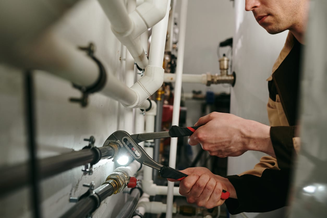 Plumbers maintaining commercial plumbing pipes in Longmont