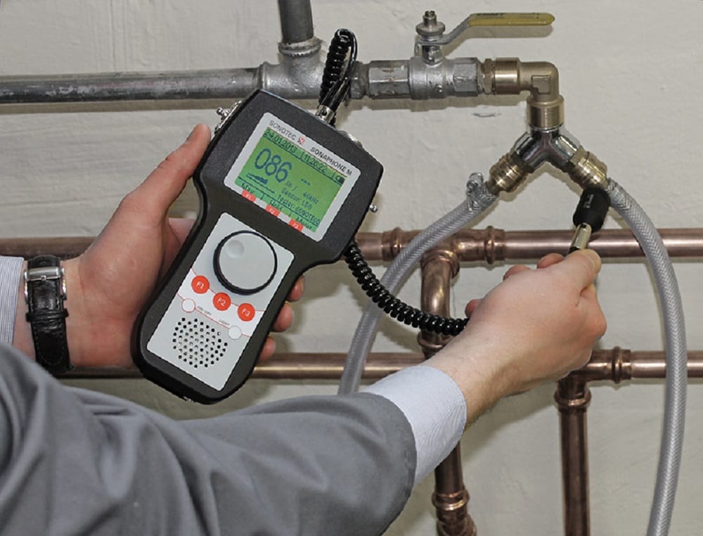 Plumber testing pipes with electronic leak detection equipment in Longmont