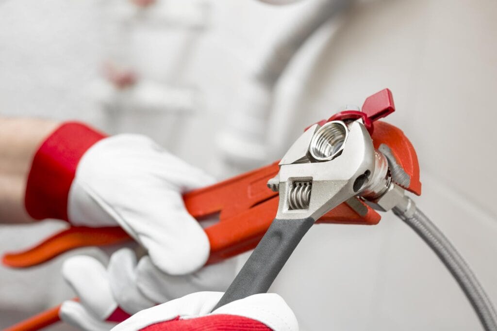 Plumber holding pipe wrenches for an emergency repair in Longmont
