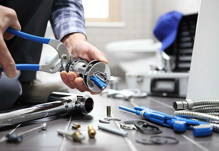 Technician repairing a plumbing fixture with professional tools in Longmont