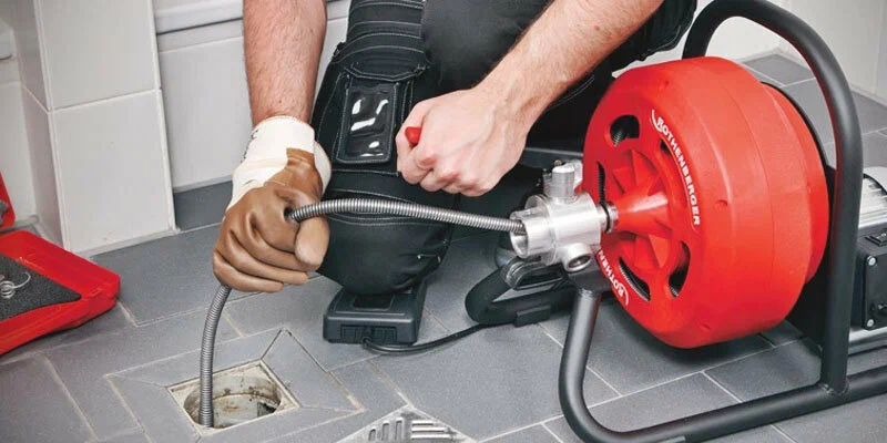 Plumber using a drain-cleaning machine in Longmont