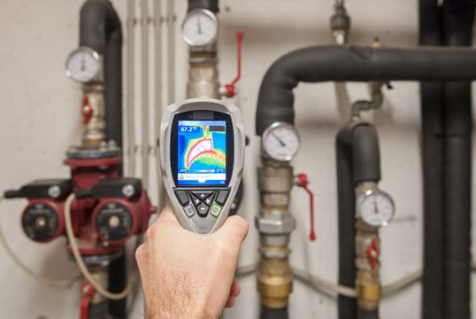 Plumber using a thermal imaging camera to inspect pipes in Longmont