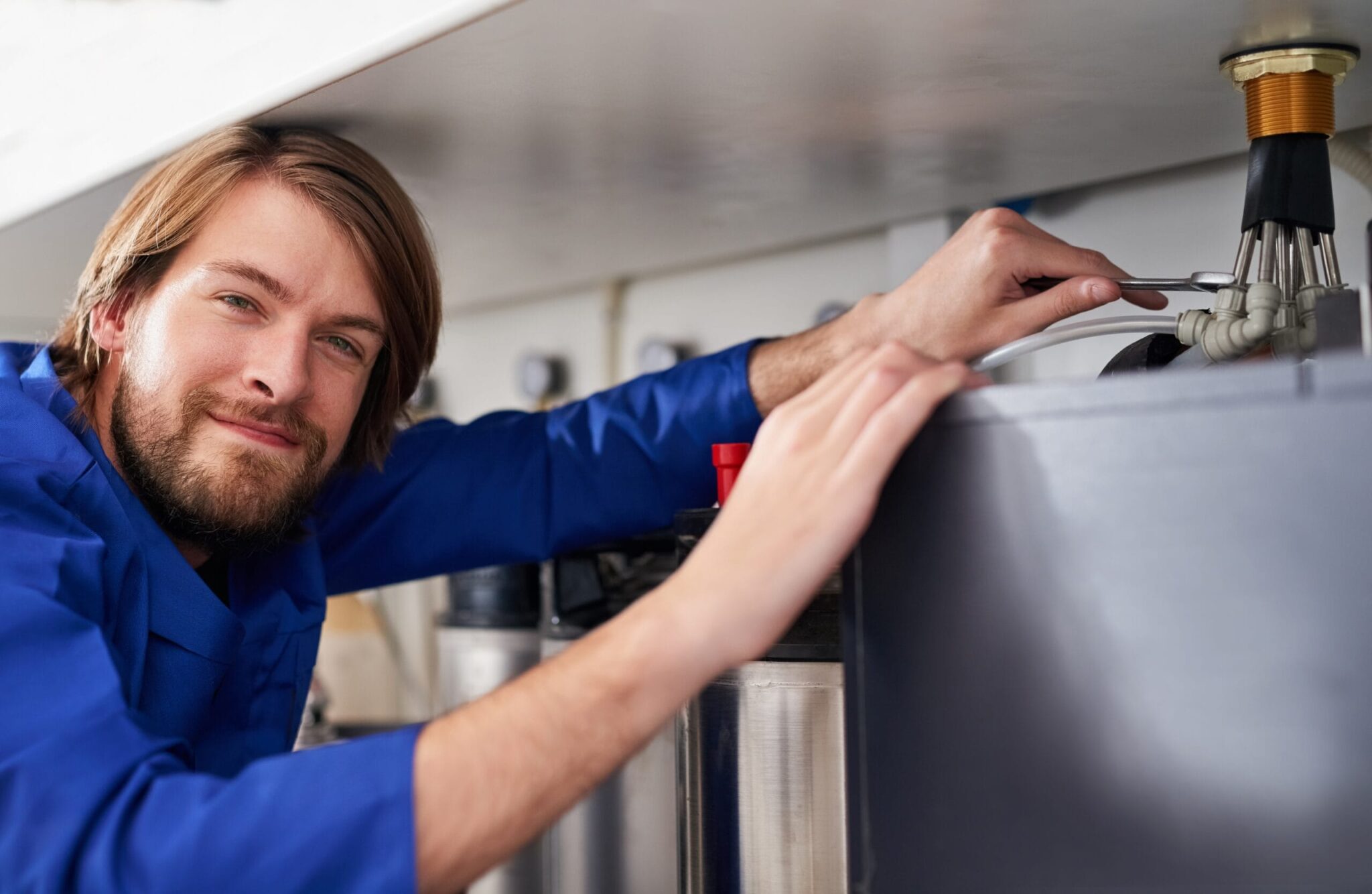 Technician servicing a residential water heater tank in Longmont