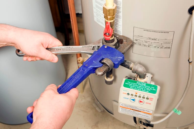 Plumber repairing a water heater valve in Longmont